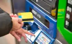 a person using a credit card to pay for a machine