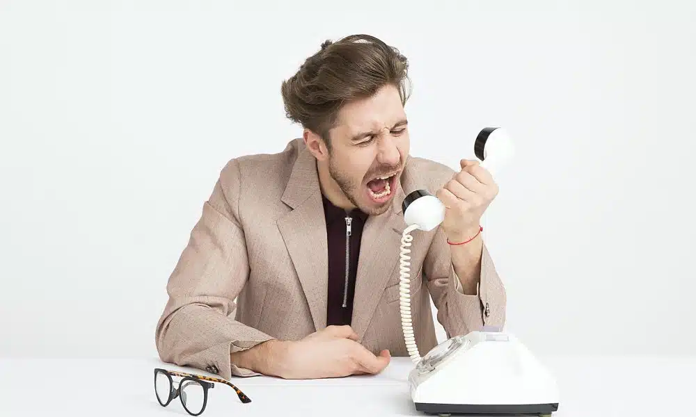 man holding telephone screaming