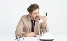 man holding telephone screaming