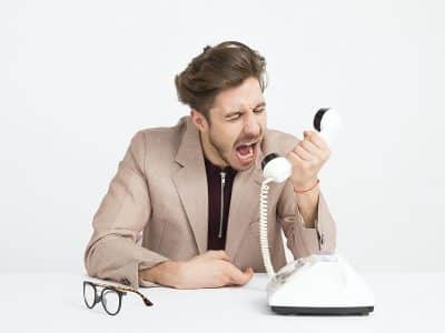 man holding telephone screaming