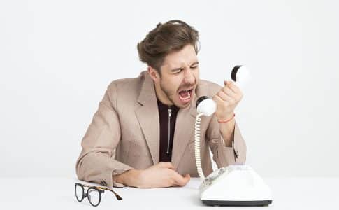 man holding telephone screaming